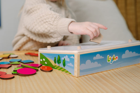 Child playing with a colorful wooden toy on a table.